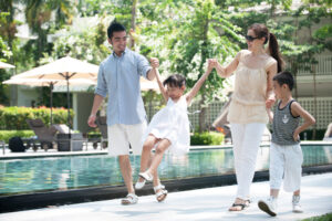 夏の日差しの中手をつなぎ歩く親子四人