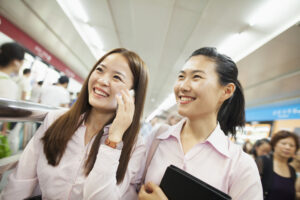 襟付きシャツを着て笑顔で歩く若い女性二人