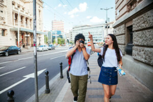 街中を歩いてくる中国人カップル、男性はカメラを構えながら女性の向かって左側を歩く