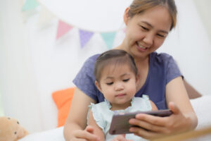 子供とスマホをのぞき込むお母さん