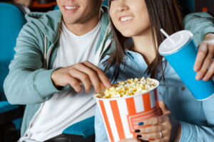 ポップコーンを手に映画鑑賞する男女