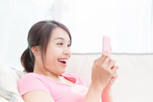 スマホを見て大笑いしている女性